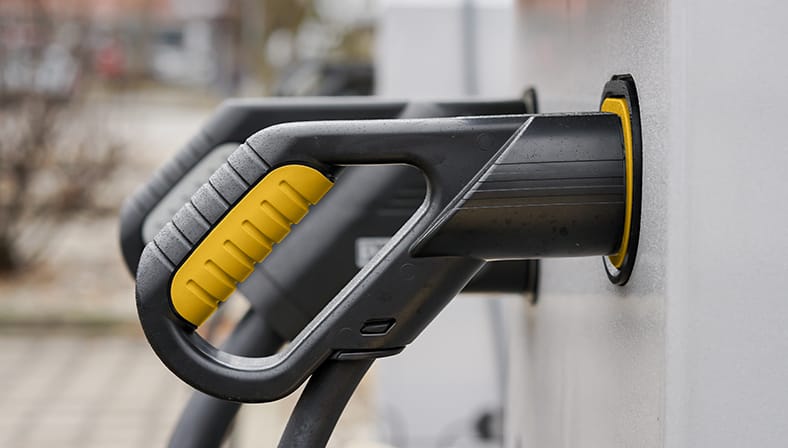 Ladestecker einer Elektroauto-Ladesäule mit gelbem Griffdetail